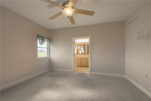 unfurnished bedroom featuring ensuite bath, ceiling fan, and light carpet