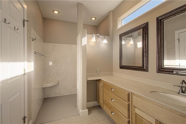 bathroom featuring tile patterned flooring, vanity, and tiled shower