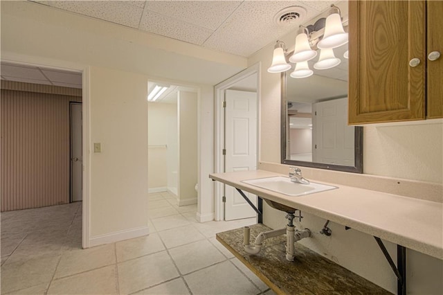 bathroom featuring tile patterned flooring, a paneled ceiling, and sink