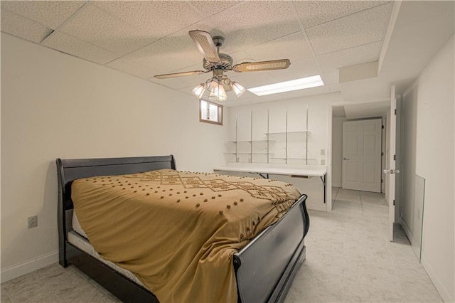 bedroom with ceiling fan and a drop ceiling