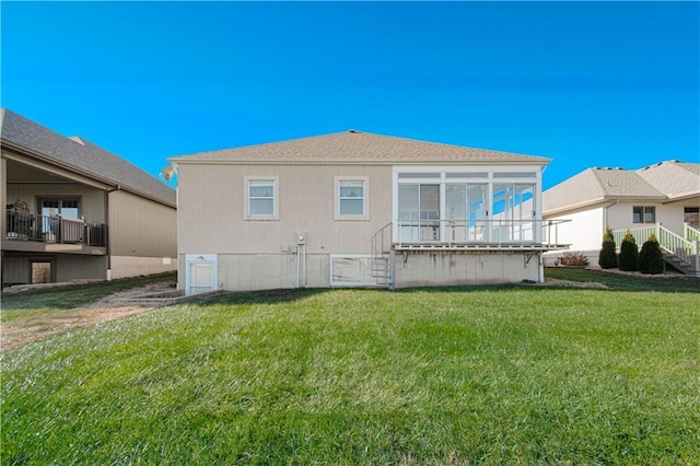 back of property with a lawn and a sunroom