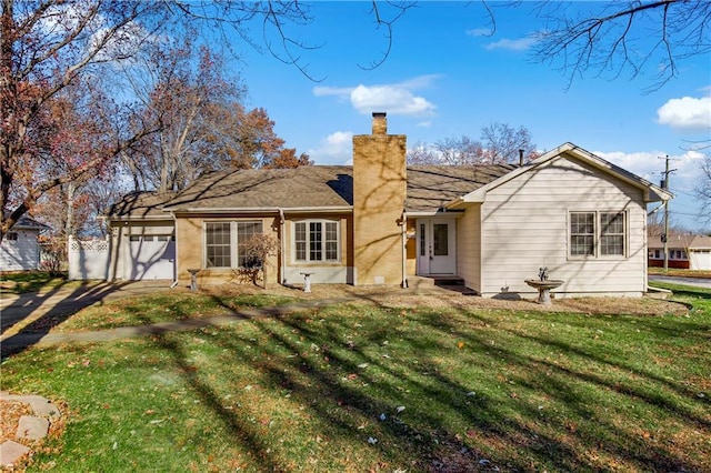 back of house with a yard and a garage