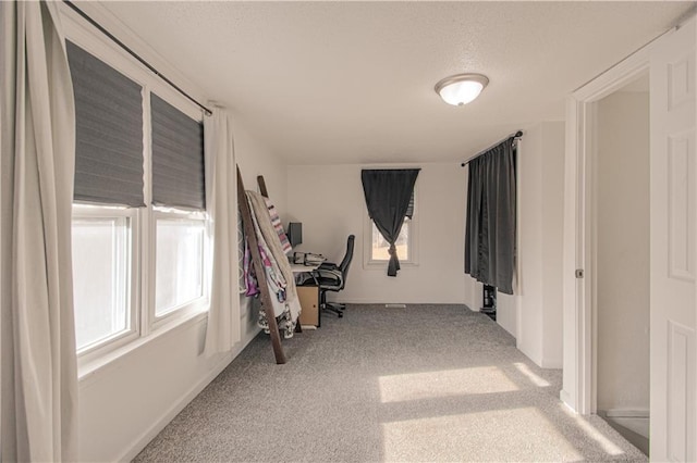 corridor featuring a wealth of natural light and light colored carpet