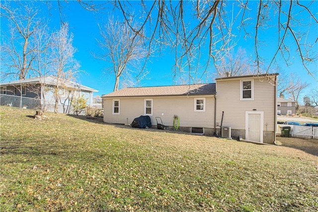 back of house with a lawn and central AC unit