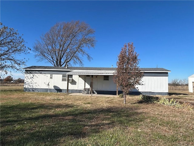 rear view of property featuring a lawn