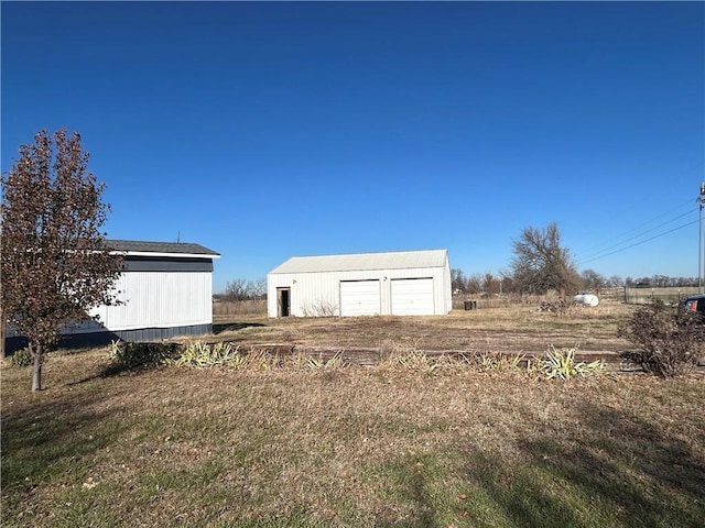 view of yard featuring a garage and an outdoor structure