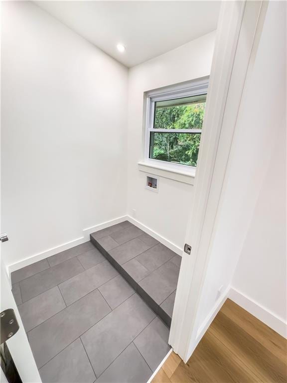 washroom with wood-type flooring and hookup for a washing machine