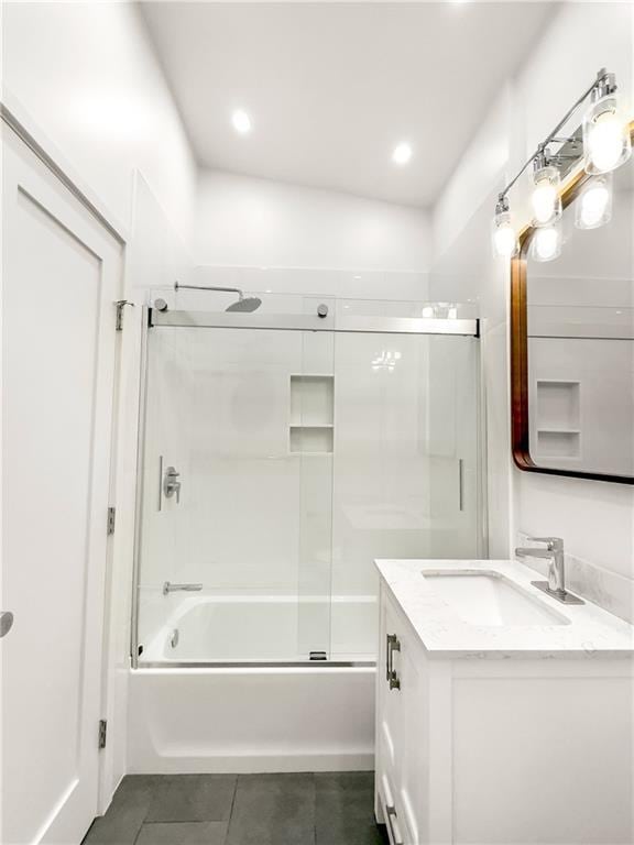 bathroom featuring tile patterned flooring, vanity, vaulted ceiling, and combined bath / shower with glass door