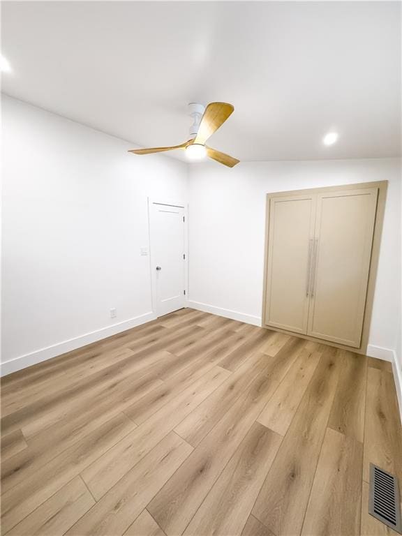 unfurnished bedroom featuring ceiling fan, a closet, and light hardwood / wood-style flooring
