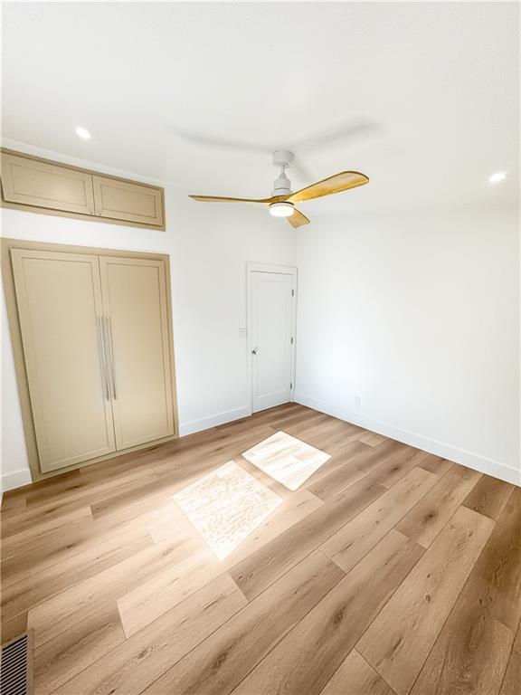 unfurnished bedroom with a closet, ceiling fan, and light hardwood / wood-style flooring