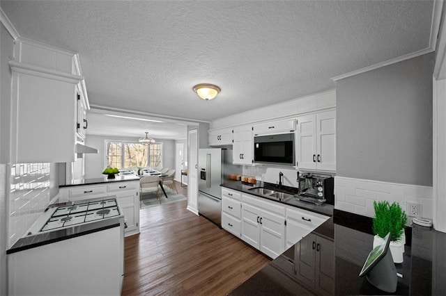 kitchen featuring white cabinetry, sink, dark wood-type flooring, stainless steel appliances, and a textured ceiling