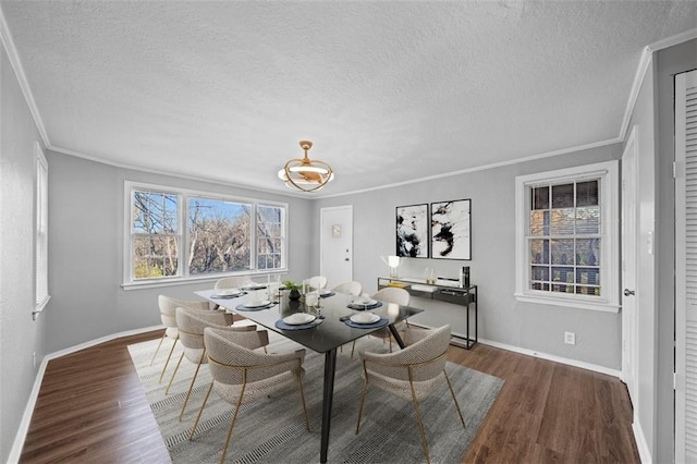 dining room with dark hardwood / wood-style flooring, a textured ceiling, and ornamental molding