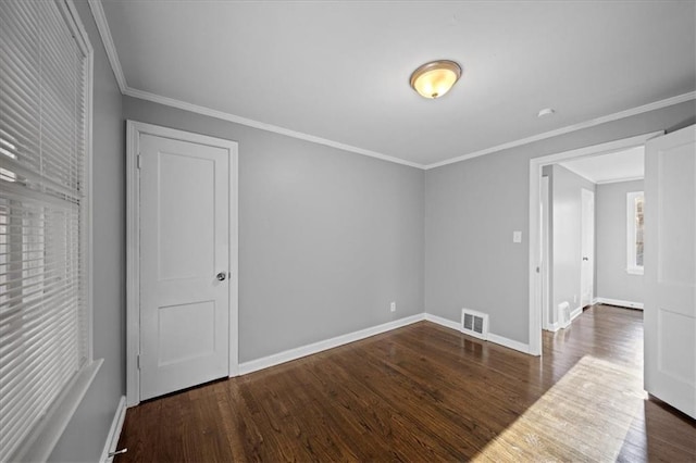 empty room with dark hardwood / wood-style flooring and ornamental molding