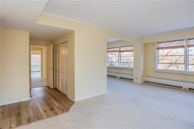 empty room featuring light hardwood / wood-style floors and a baseboard radiator