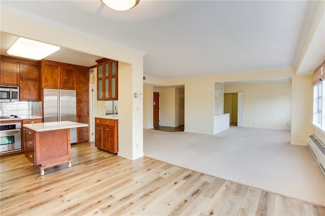 kitchen featuring a center island, stainless steel appliances, light hardwood / wood-style flooring, and ornamental molding