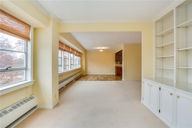 unfurnished room with light hardwood / wood-style floors, baseboard heating, and ornamental molding