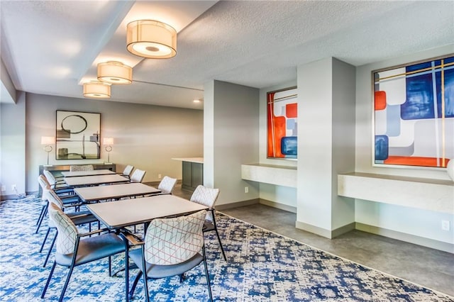 dining space featuring concrete flooring and a textured ceiling