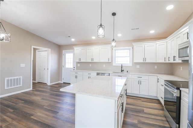 815 SW 520th Rd, Holden, MO 64040 - kitchen featuring appliances with stainless steel finishes, a kitchen island, dark wood finished floors, white cabinets, and decorative light fixtures