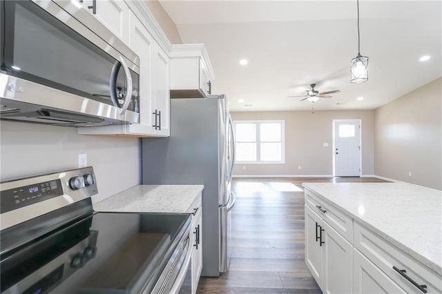 kitchen featuring white cabinetry, dark wood-type flooring, light stone counters, decorative light fixtures, and appliances with stainless steel finishes