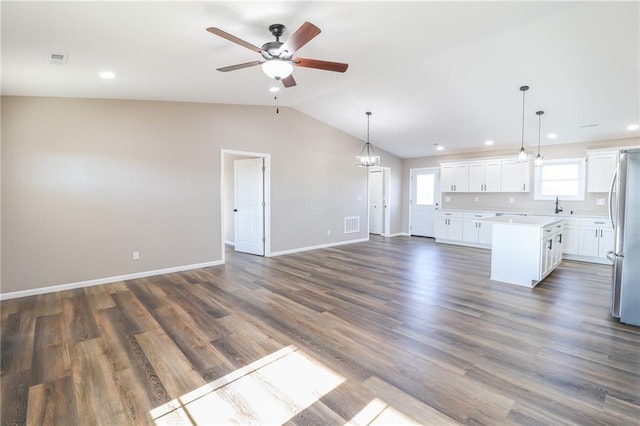 interior space featuring a center island, hanging light fixtures, dark hardwood / wood-style floors, lofted ceiling, and white cabinets