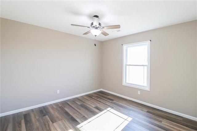 empty room with ceiling fan and dark hardwood / wood-style floors