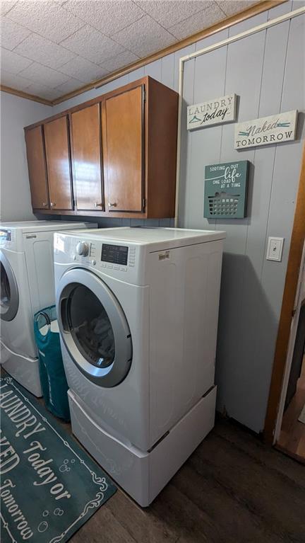 washroom featuring dark hardwood / wood-style flooring, cabinets, and independent washer and dryer