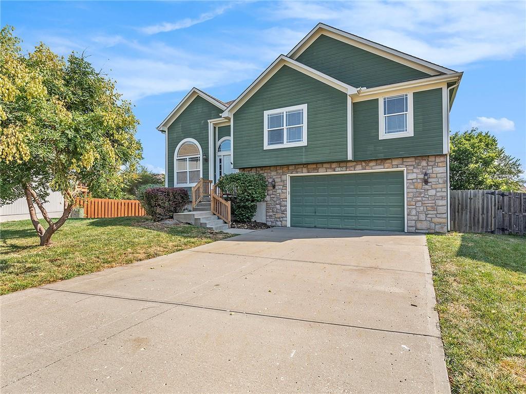 split foyer home with a garage and a front yard