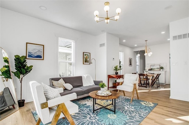 living room featuring light hardwood / wood-style floors and a notable chandelier