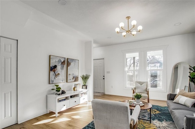 living room with an inviting chandelier and light hardwood / wood-style flooring