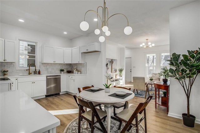 dining room featuring sink, a chandelier, and light hardwood / wood-style floors