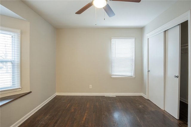 unfurnished bedroom with a closet, dark hardwood / wood-style floors, and ceiling fan