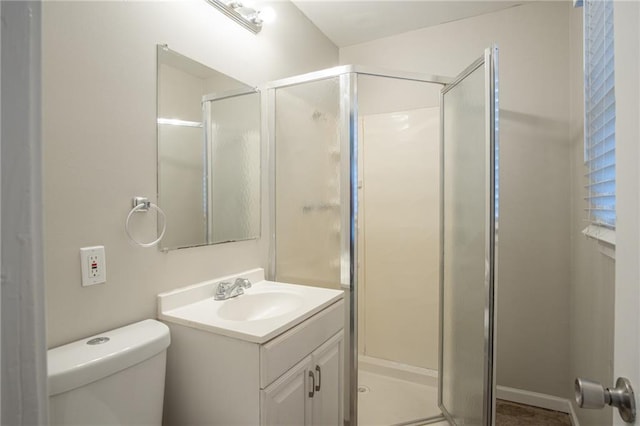 bathroom with vanity, toilet, and a shower with door