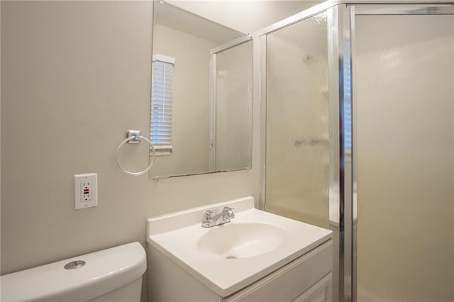 bathroom featuring vanity, toilet, and a shower with shower door