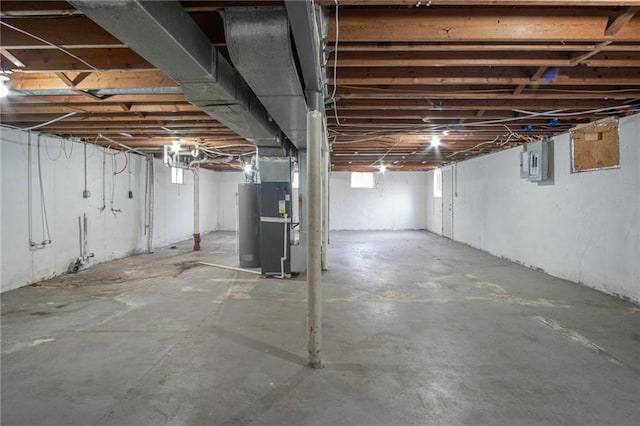 basement featuring electric panel and heating unit