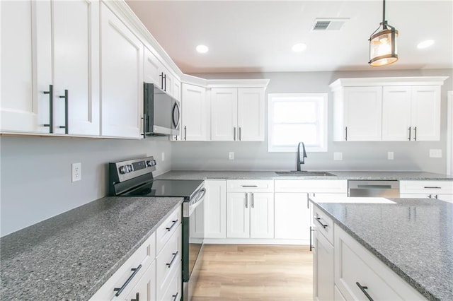 kitchen featuring white cabinets, stainless steel appliances, light hardwood / wood-style flooring, and sink