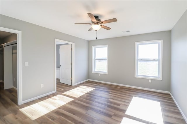 unfurnished bedroom with ceiling fan, a closet, and wood-type flooring