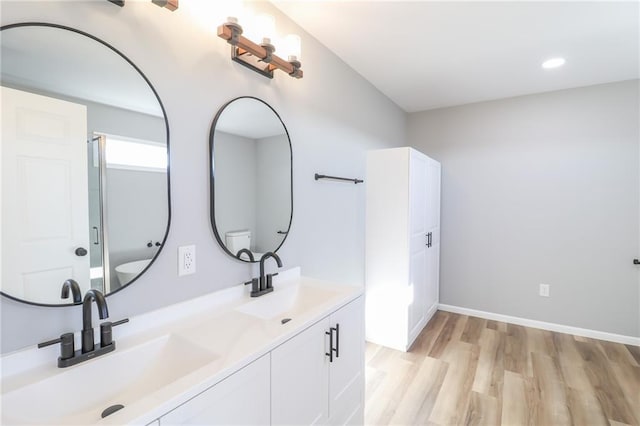 bathroom with vanity, wood-type flooring, and walk in shower