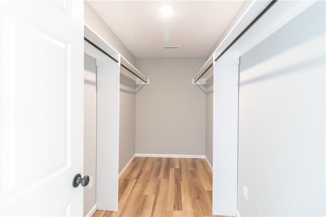 spacious closet featuring light hardwood / wood-style floors