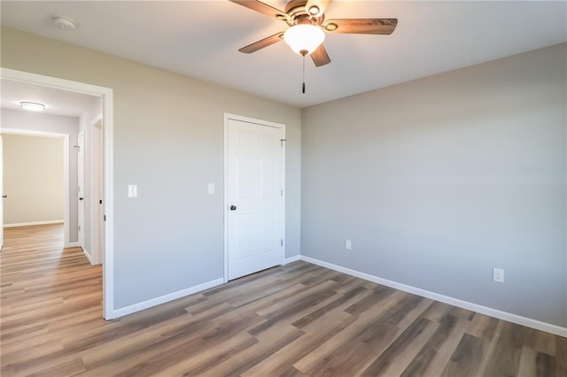 unfurnished bedroom featuring ceiling fan, a closet, and wood-type flooring