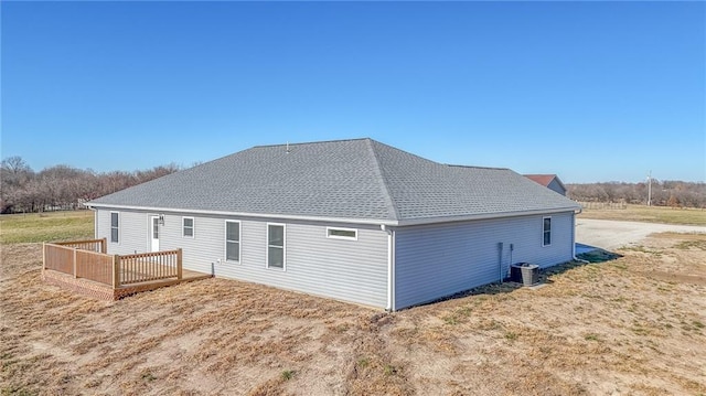 back of property with central AC unit and a wooden deck