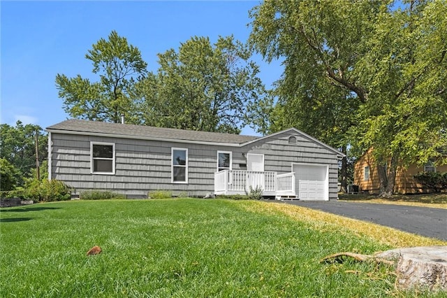 ranch-style home with a garage, a front lawn, and a deck