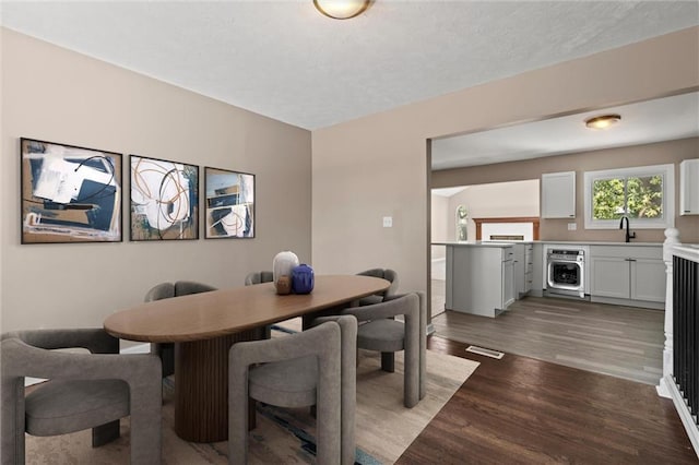 dining space with dark wood-type flooring and sink