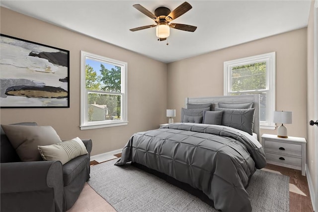 bedroom with light hardwood / wood-style flooring, multiple windows, and ceiling fan