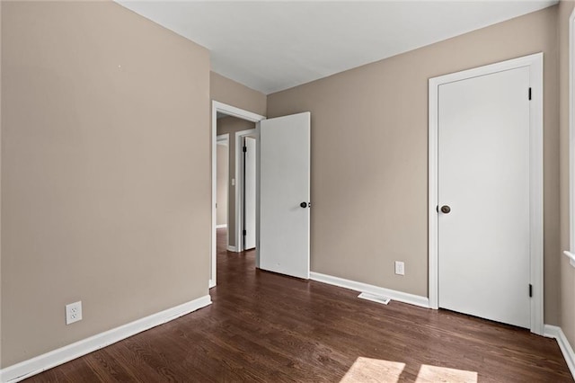 unfurnished bedroom with dark wood-type flooring