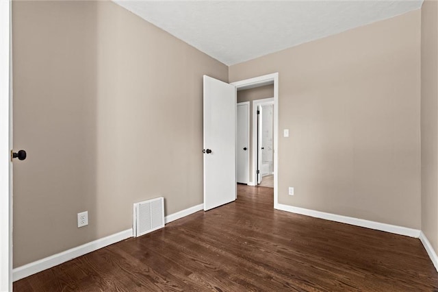 unfurnished room with dark wood-type flooring