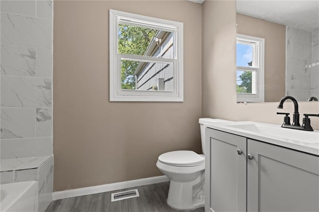 bathroom with vanity, a healthy amount of sunlight, toilet, and wood-type flooring