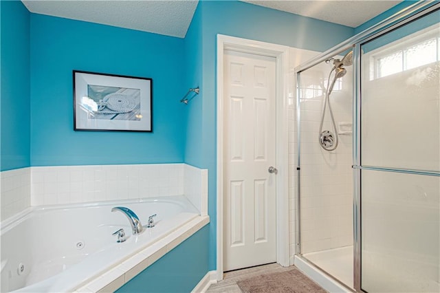 bathroom featuring separate shower and tub and a textured ceiling