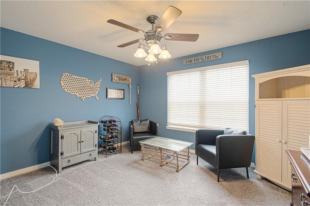 sitting room with a textured ceiling, ceiling fan, and carpet