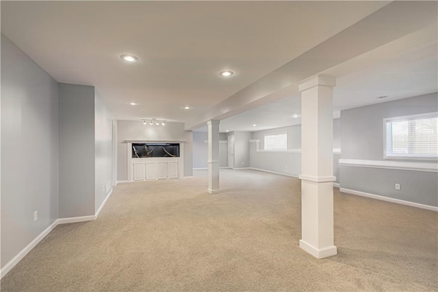 basement with light colored carpet and rail lighting