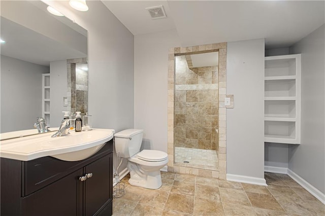 bathroom with vanity, a shower with shower door, built in features, and toilet